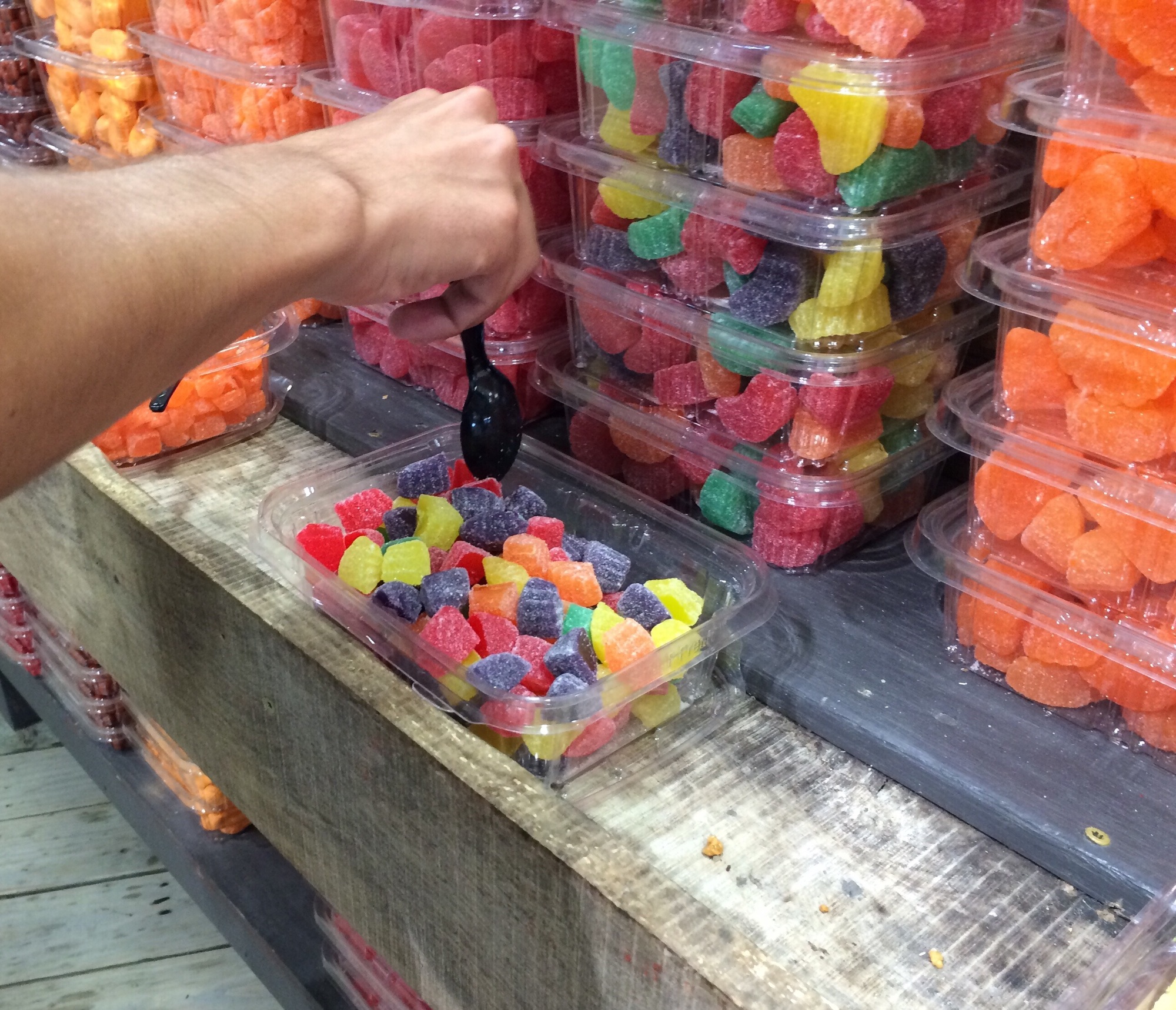 Person getting free samples in the candy section of the farmer's market.