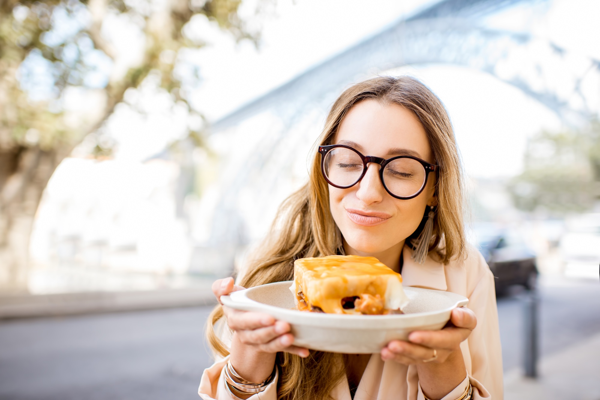 Woman with francesinha meal in Porto city