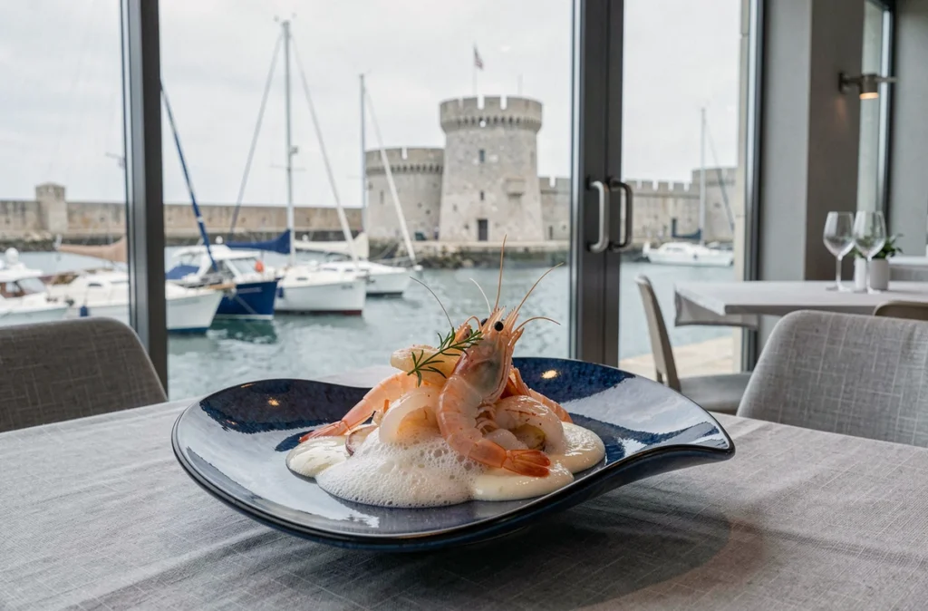 Assiette de fruits de mer et langoustines au restaurant Christopher Coutanceau avec vue sur le vieux port de La Rochelle en arrière-plan